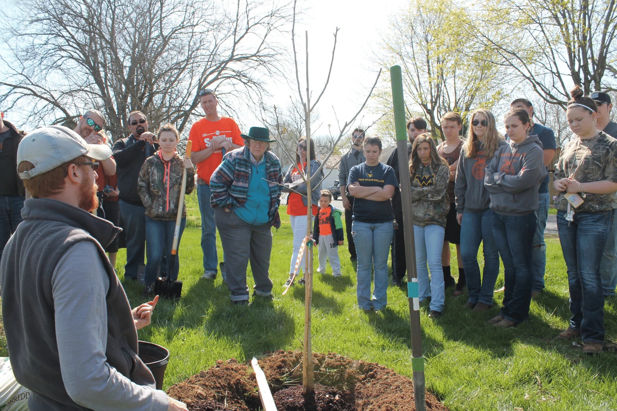 tanner haid in front of trees teaching how to plant trees 